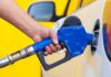 Mystery Crash Near Global Oil Hub Kills 14 A person refueling a car at a gas station with a blue nozzle