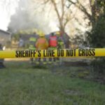 A Lake Party, A Missing Teen, and a BUI Arrest Yellow police tape marking a restricted area at a fire scene with firefighters in the background