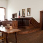 Supreme Court Assassin Gets Less Than 9 Years as DOJ Appeals Interior of a historic courtroom with wooden furniture and an American flag