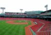 View of an empty Fenway Park baseball stadium with green grass and red seats