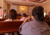 A Shrine, a Tragedy, and a Tough Question People sitting in church pews during service.