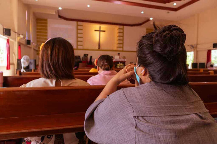 1773600770 People sitting in church pews during service.
