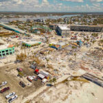 Coast Guard Says Seven Rescued After Barge Collision Aerial view of hurricane-damaged buildings and debris.