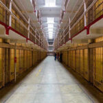 Idaho Chooses Firing Squads Over Lethal Injection Long hallway with prison cells on both sides.