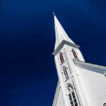 White church steeple against deep blue sky