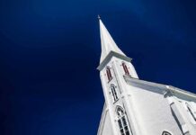 White church steeple against deep blue sky