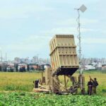 Military defense system deployed in a field with soldiers nearby