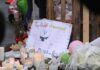 Federal Agents Killed the Wrong Man A memorial site with candles, flowers, and a hand-drawn poster