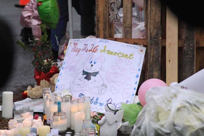 shutterstock_122814760 A memorial site with candles, flowers, and a hand-drawn poster