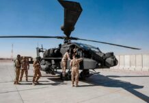 Iran Strikes U.S. Bases as Middle East War Escalates Soldiers inspect a military attack helicopter on a tarmac