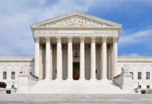 Woman Restriction: Supreme Court Weighs Fairness Front view of the Supreme Court building with large columns and steps under a blue sky