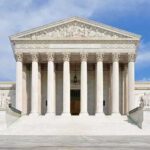 Supreme Court Hands Trump: A 91-Year Precedent Falls Front view of the Supreme Court building with large columns and steps under a blue sky