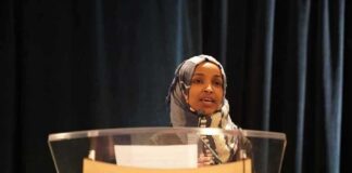 Woman in hijab speaking at a podium