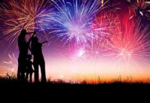Culture War: Half a Million Gather Under One Flag Silhouetted figures watching a colorful fireworks display against a twilight sky