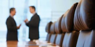 Two business professionals engaged in conversation in a conference room