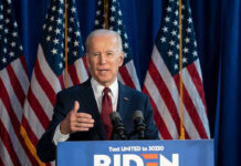 Court Halts Release of Biden Audio Tapes Man speaking at podium with American flags behind.