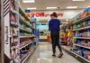 A person shopping in a CVS pharmacy aisle filled with various products