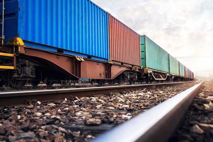 shutterstock_1660713808 Freight train with colorful shipping containers on railway tracks