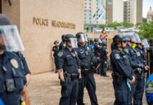 Terror Bombshell: State Department Targets Far-Left Groups Police officers in riot gear stand in formation outside a headquarters building
