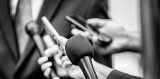Microphones and recorders held toward a speaker