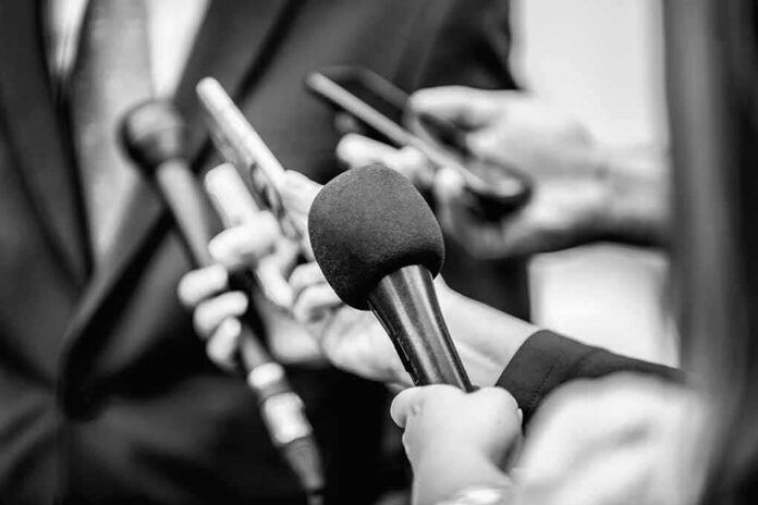 shutterstock_1821539798 Microphones and recorders held toward a speaker