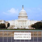 Tax Breaks for Some, Benefit Cuts for Millions View of the U.S. Capitol building with a security barrier in front