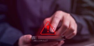 Person tapping smartphone with red warning icon
