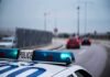 Armed and Dangerous: Worcester Police Launch Manhunt Police car with blue lights on near a roadway