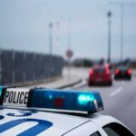 Police car with blue lights on near a roadway