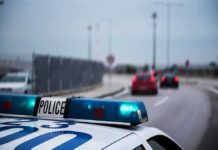 Police car with blue lights on near a roadway