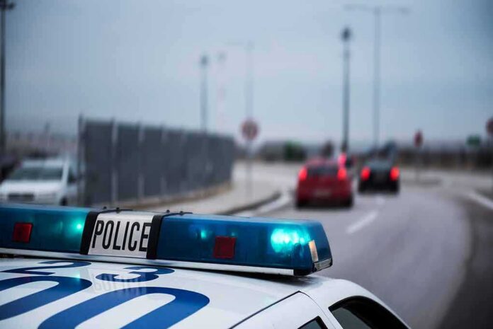 Police car with blue lights on near a roadway