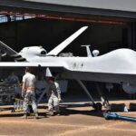 The U.S. Is Building Its Next Air Dominance Fighter Military drone being serviced by ground crew outside a hangar