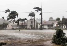 Houses battered by hurricane winds and flooding