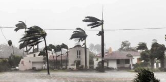 Houses battered by hurricane winds and flooding