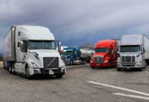 DOT Shuts Down 110 Trucking Schools Over Language Rules Semi trucks parked at a rest area under cloudy sky