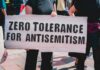 Protester holding a large sign at a rally