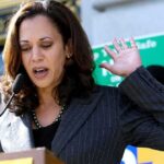 Alaska Democrat Rejects Harris’s Help Woman speaking at an outdoor podium with hand raised