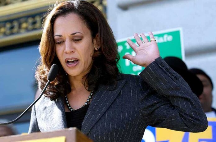 Woman speaking at an outdoor podium with hand raised