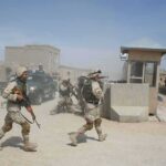U.S. Forces Intercept Iranian Missile Attack Soldiers in desert uniforms run past a checkpoint amid dust