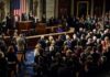 Legislators give a standing ovation in a grand chamber