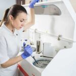 Lab technician using an analyzer with a pipette