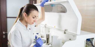 Lab technician using an analyzer with a pipette
