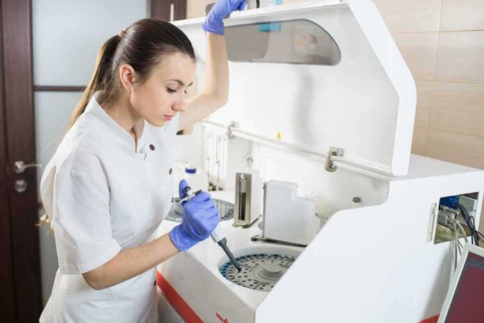 shutterstock_296643947 Lab technician using an analyzer with a pipette