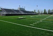 Rogue Parrot Halts Youth Soccer Match Twice Empty football stadium with bleachers and artificial turf field