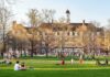 Students relaxing on a campus quad in front of a brick academic building
