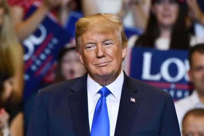 Donald Trump at a rally wearing a dark suit and blue tie