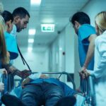 Left at ER, Freshman Dies After Frat Night Medical team rushing patient on a gurney through hospital corridor