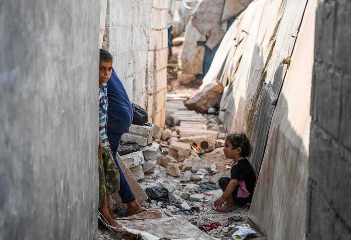 children in a narrow alley with rubble