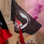 Court Orders and Police Protection Keep on Track protesters with antifascist flags and purple smoke