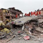 7.4 Quake Rocks Colombia Rescue workers in orange uniforms on a collapsed building site after an earthquake